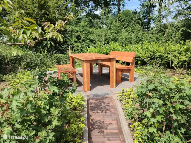 Fijn zitje met stoere tafel en banken. Oja ook in de tuin voldoende stroompunten en lichtjes